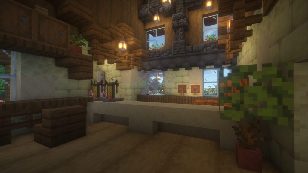 マインクラフトで建築したカフェの注文カウンター。滑らかな砂岩のカウンター越しに、奥のキッチンが見えるオープンな造り。