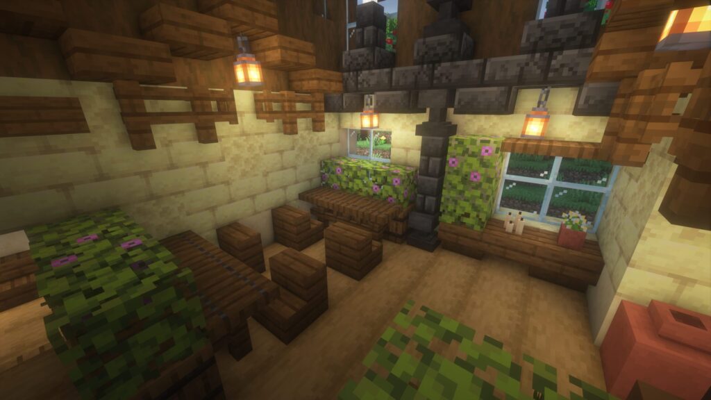 マインクラフトで建築したカフェの客席エリア。落ち着いた色合いの一人掛け席が並び、壁面には深層岩のブロックを組み合わせた重厚な柱の装飾が施されている。